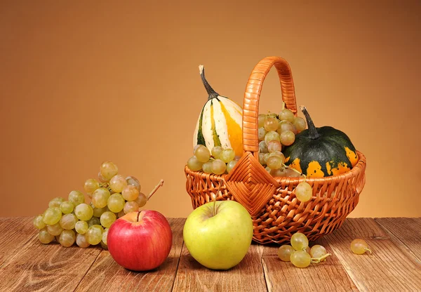 Manzanas, uvas y calabazas decorativas en cestas de mimbre — Foto de Stock