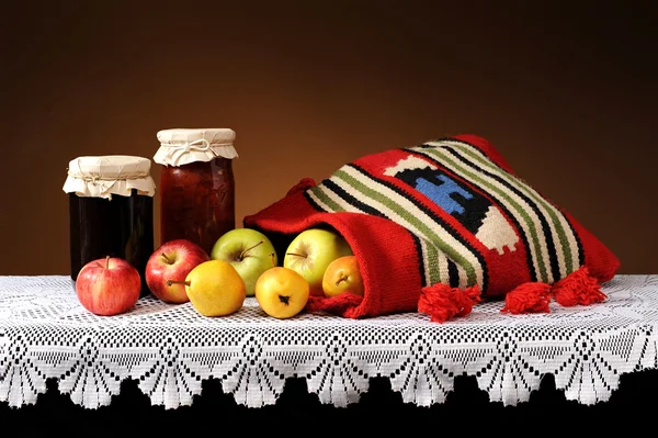 Fruits frais dans un sac de laine et confiture dans un bocal — Photo