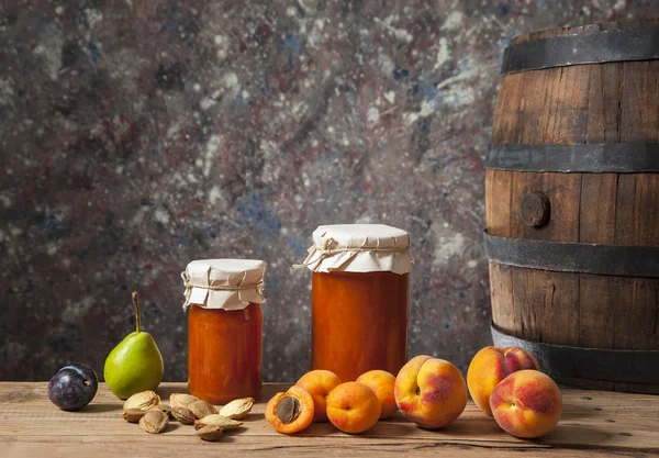 Apricot jam, fresh fruit and a wooden barrel — Stock Photo, Image