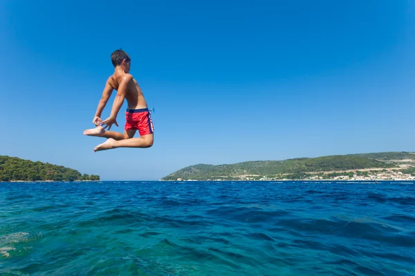 Kid jumps in sea — Stock Photo, Image