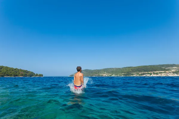 Kid jumps in sea — Stock Photo, Image