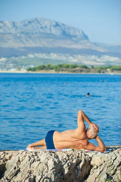 Oudere man op het strand — Stockfoto