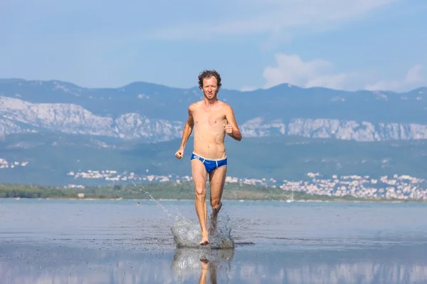 Άνθρωπος που τρέχει απέναντι από την παραλία — Φωτογραφία Αρχείου