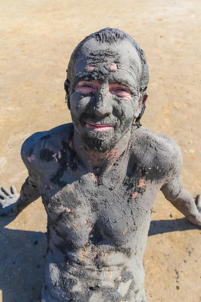 Человек, испачканный целебной грязью — стоковое фото
