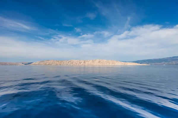 Hırvat adada mavi gökyüzü ve dalgalı deniz manzarası — Stok fotoğraf