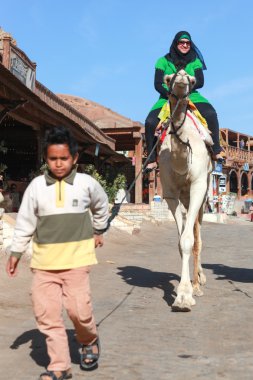 bir deve üzerinde kadın turist