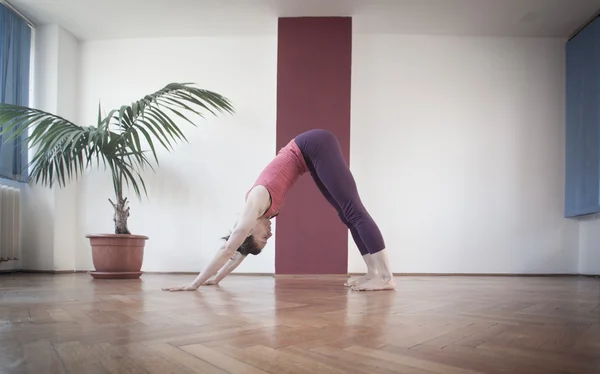 Junge Frau praktiziert Yoga im Yogazentrum. — Stockfoto