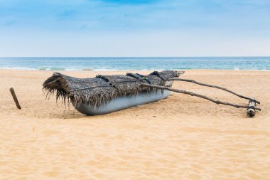 boş kum plajındaki geleneksel sri Lankalı balıkçı teknesi.