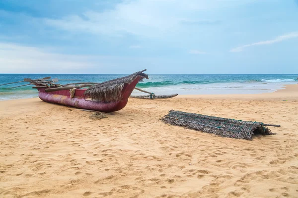 Tradycyjne sri Lanki połów łódka na pustej plaży. — Zdjęcie stockowe