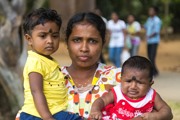 Portrait of local woman holding two kids — Stock Photo, Image