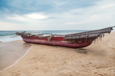 boş kum plajındaki geleneksel sri Lankalı balıkçı teknesi.