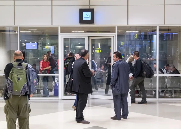 Pessoas dentro e em frente à sala de fumantes no Aeroporto Internacional de Doha — Fotografia de Stock