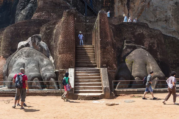 Grupp turister framför lejon tass på sigiriya komplexa — Stockfoto