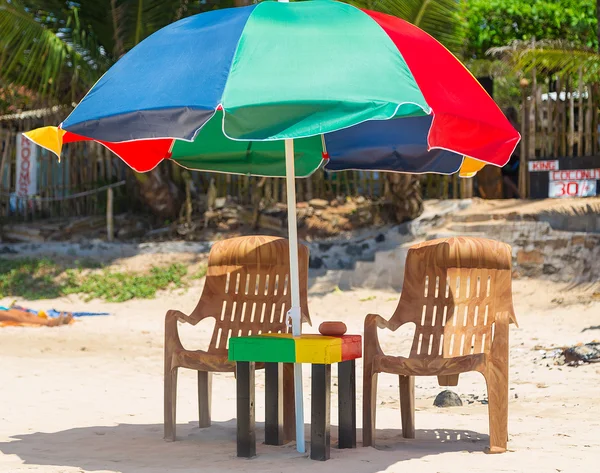 Tafel, stoelen en kleurrijke parasol — Stockfoto