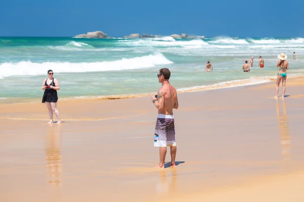 Turistas em pé na praia arenosa — Fotografia de Stock
