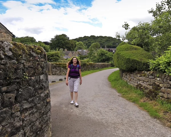 Una mujer camina por un camino de pueblo inglés — Foto de Stock