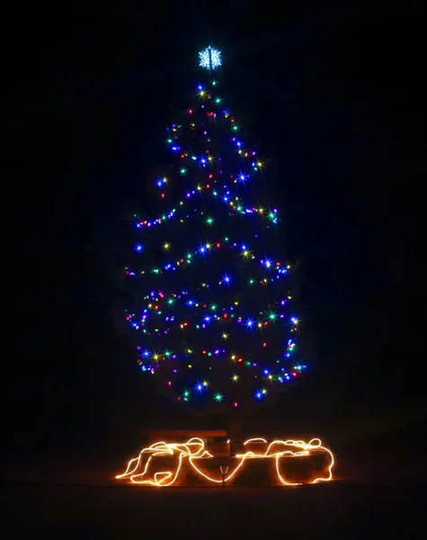 Uma árvore de Natal ao ar livre em uma noite escura — Fotografia de Stock