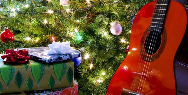 ağacın altında kırmızı bir klasik gitar