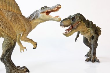 un spinosaurus se enfrenta con un tiranosaurio rex