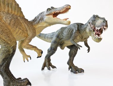 un spinosaurus se enfrenta con un tiranosaurio rex