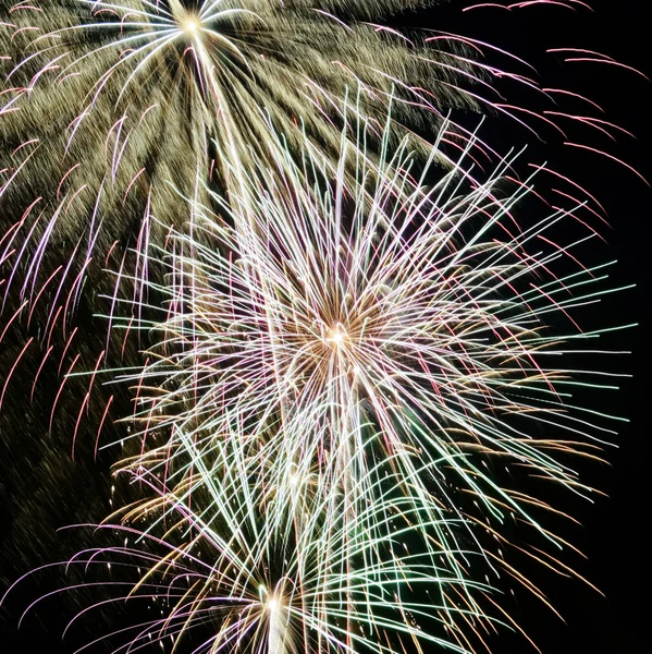 Um céu noturno cheio de fogos de artifício explosivos — Fotografia de Stock