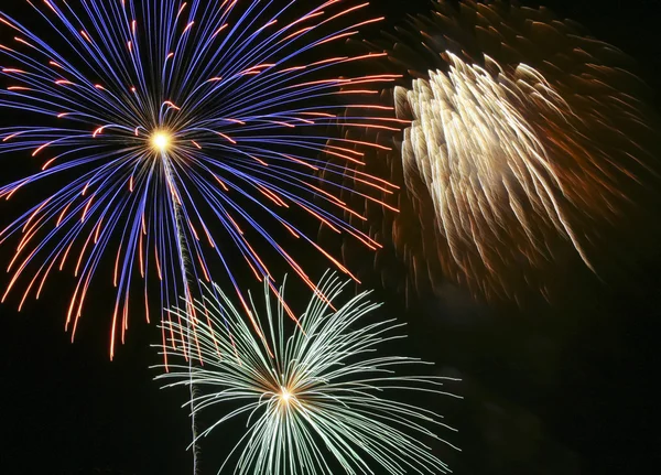 Um céu noturno cheio de fogos de artifício explosivos — Fotografia de Stock