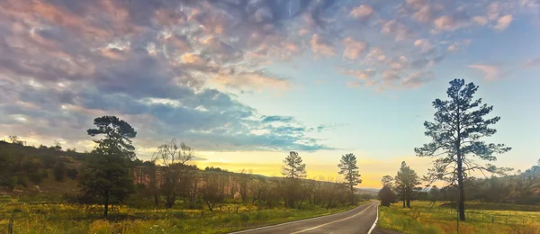 Un camino en un valle montañés al amanecer — Foto de Stock