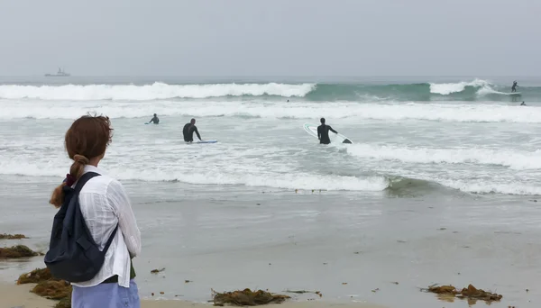 Una mujer en una playa Relojes Surfistas — Foto de Stock