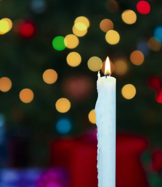 Uma vela de Natal branca com luzes embaçadas — Fotografia de Stock