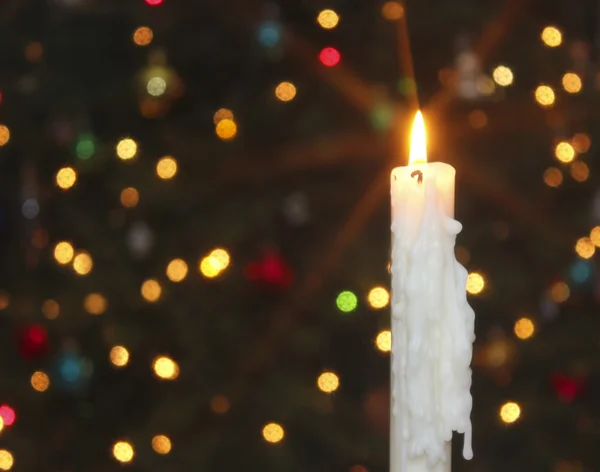 Eine weiße Weihnachtskerze mit verschwommenem Licht — Stockfoto