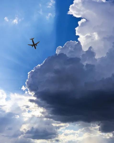 Ein Flugzeug, blauer Himmel, Wolken und Sonnenstrahlen — Stockfoto