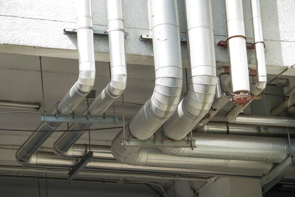 Tuyaux de gaz en acier sur un mur de bâtiment Photos De Stock Libres De Droits