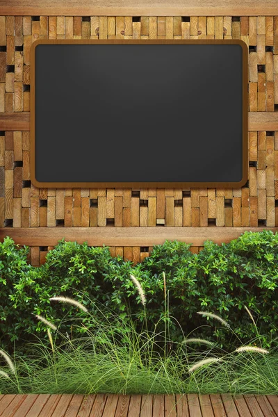 Quadro negro vazio com moldura de madeira na parede de madeira — Fotografia de Stock