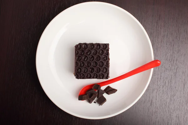 Chocolate cake on table with red spoon — Stock Photo, Image