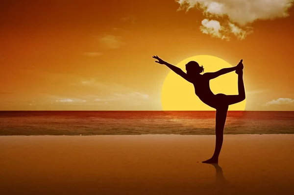 在镜像日落海滩的美丽瑜伽女人的剪影 — 图库照片