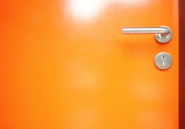Orange dörr med metall dörrhandtag — Stockfoto