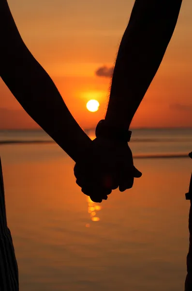 Siluetas parejas manos en la puesta del sol — Foto de Stock