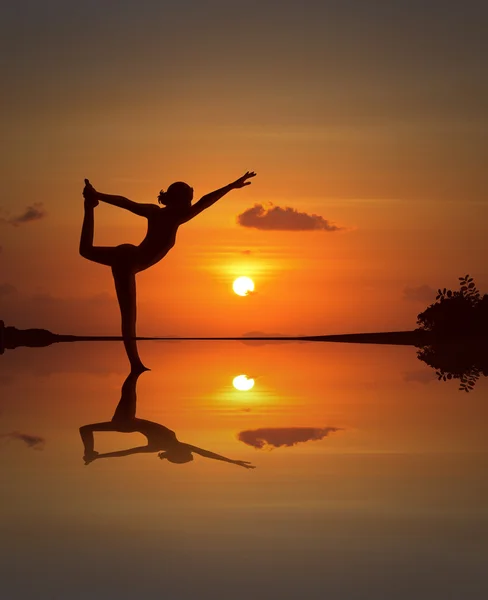 Silhueta de uma bela mulher Yoga em praia de pôr do sol espelhado — Fotografia de Stock