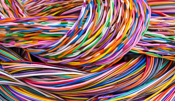 Colorful background of multicore cables bunch. Detail of wiring loom tangle. Closeup of beautiful braids from electric wires with plastic insulation in abstract colored texture. Electrotechnics. Tech.