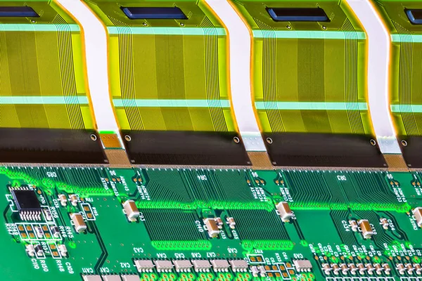 曲げフレキシブル部品に印刷された複数のワイヤ接続を備えた回路基板上の電子部品 Lcdデバイス用のプラスチックFpcインタフェースを実装した緑のPcb上の抵抗 コンデンサ チップ — ストック写真