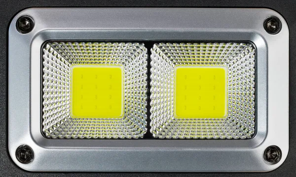 High power photographic electric LED lamp in plastic reflective surface. Close-up of professional reflector from two yellow arrays of electronic semiconductor light emmiting diodes. Electrotechnology.