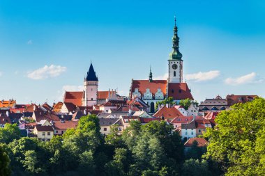 View to historical center of Tabor old town with towers, red rooftops and blue sky. Gothic church with renaissance gables - Czech cultural sight in scenic medieval hussites urban monument reservation.