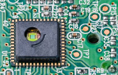 Green silicon die and gold wires inside round hole of integrated circuit. Close-up of optoelectronic sensor on PCB of optical laser computer mouse with surface mount assembly of electronic components. clipart