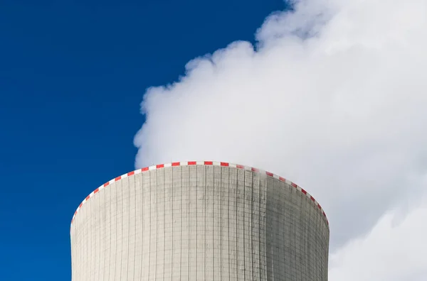 Closeup of cooling tower top with warning red broken line and white steam plume on a blue sky background. Waste heat rejection from nuclear power plant to air by water evaporation in concrete structure.