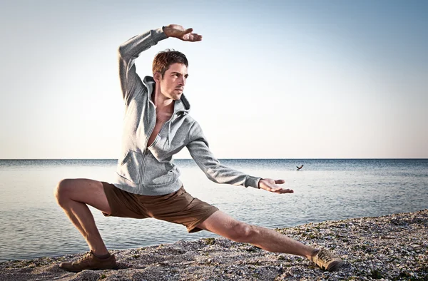 Joven hombre atractivo haciendo movimientos Thai-chi — Foto de Stock