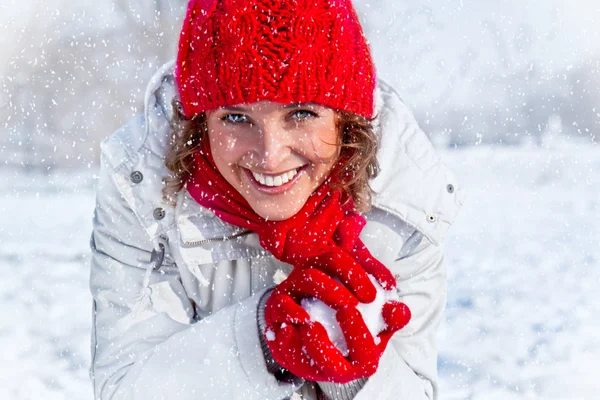 Gelukkig jonge vrouw sneeuwballengevecht spelen op de dag van de sneeuw. — Stockfoto