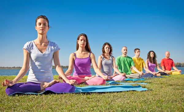 Grupo de jóvenes tienen meditación en clase de yoga . Fotos de stock libres de derechos