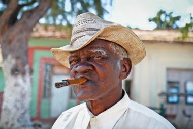 Cuban man smoking a cigar. Trinidad, Cuba. clipart