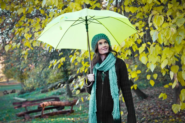 Bela jovem sob guarda-chuva amarelo — Fotografia de Stock