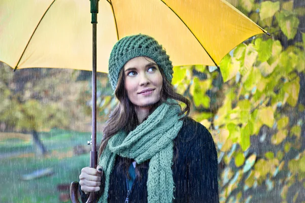 Frau mit gelbem Regenschirm lächelt — Stockfoto